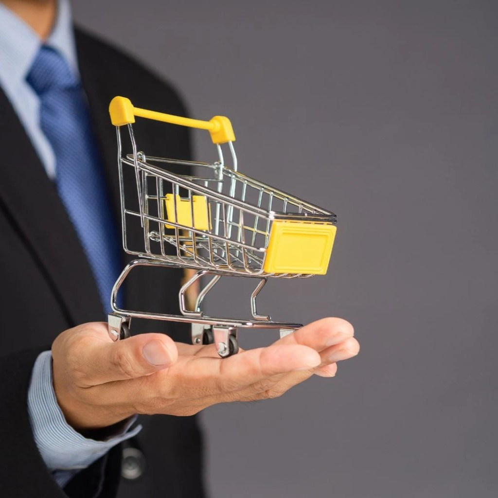 Business professional holding a shopping cart, representing ecommerce sales growth, conversion optimization, and revenue driven ecommerce SEO strategies.
